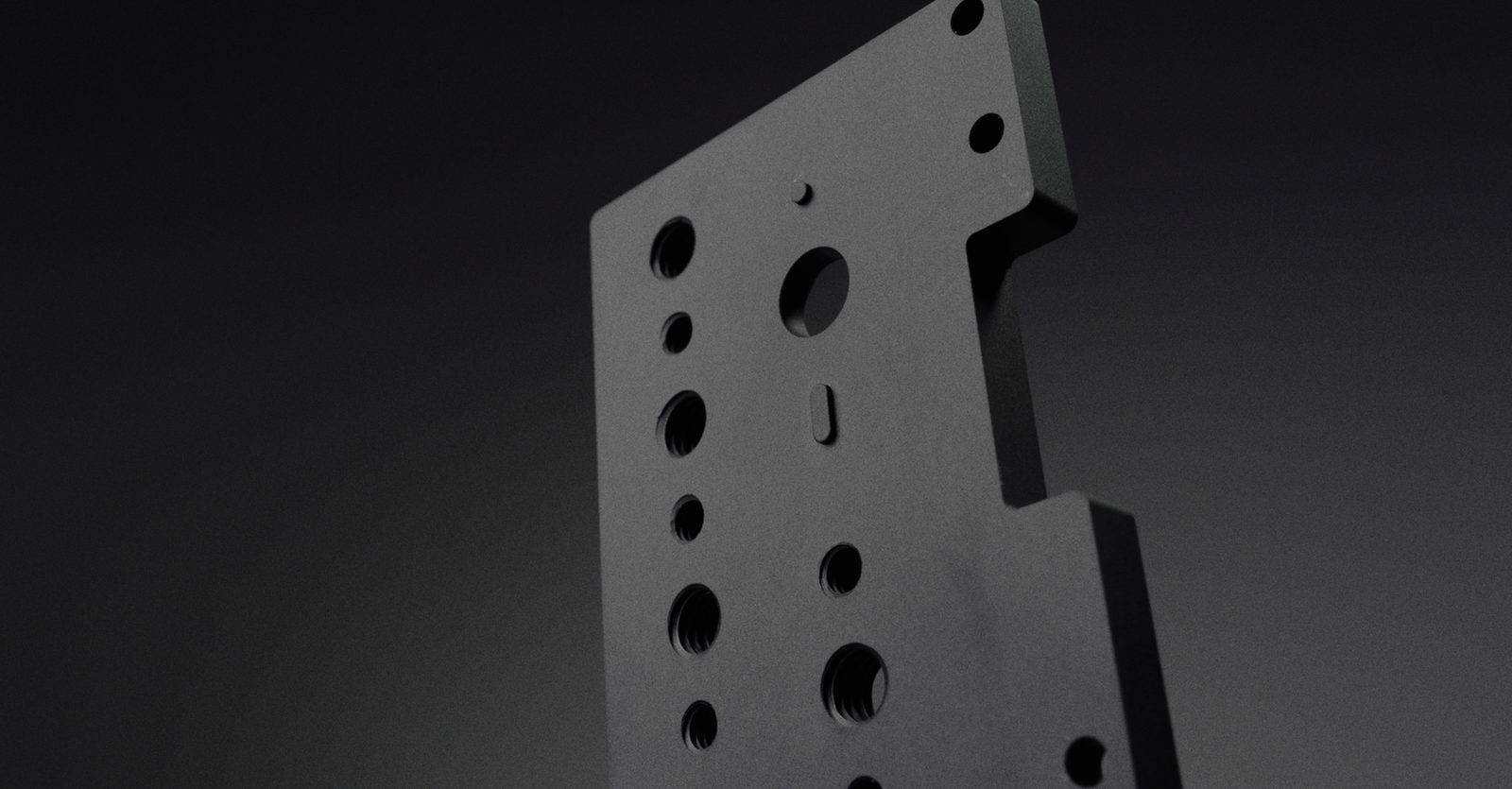 The base plate upright, showing its stepped profile and tapped holes